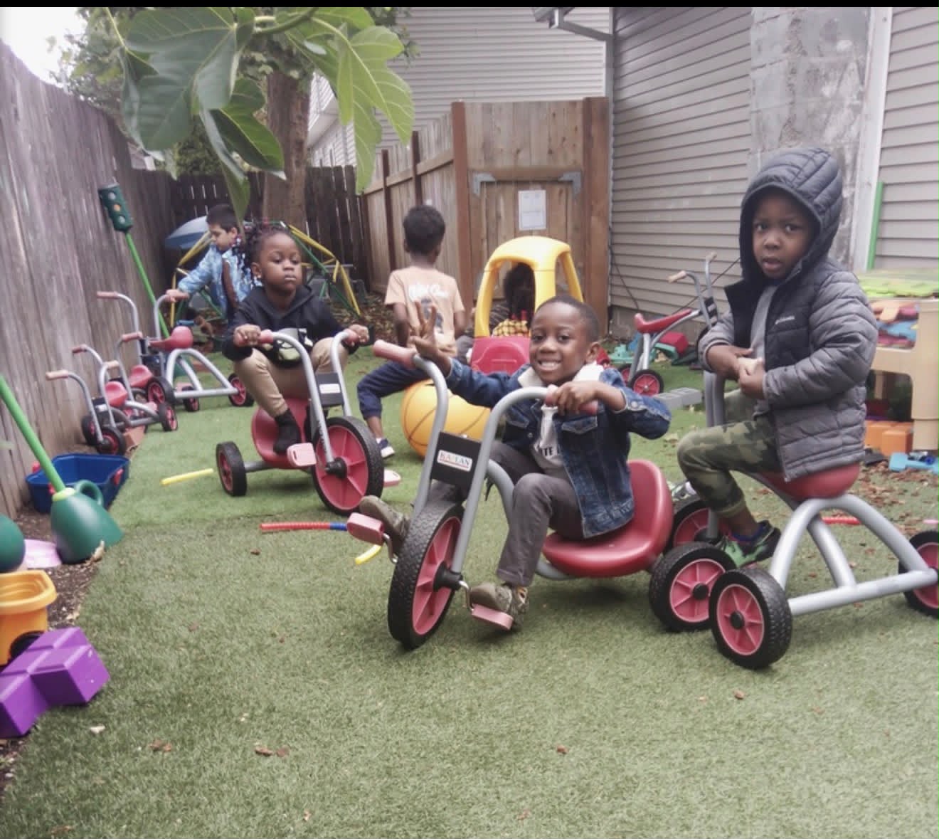 Children riding tricycles in our outdoor play area